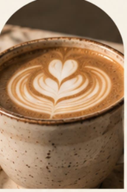 Latte with heart latte art in a speckled ceramic cup